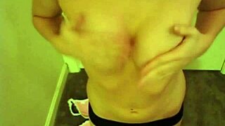 A tiny redheaded slut masturbates by rubbing her natural tits in a close-up view, feeling incredibly horny