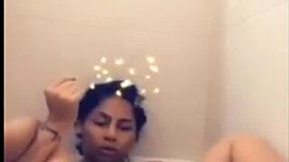 Mulatto woman indulges in solo pleasure in the bathtub, climaxing on herself