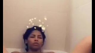 Mulatto woman indulges in solo pleasure in the bathtub, climaxing on herself