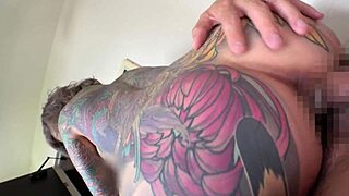 Japanese woman with full-body tattoo strips and licks erect cock