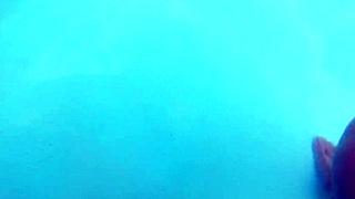 Husband films wife outdoor with two at hotel pool