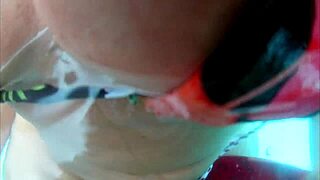 Husband films wife outdoor with two at hotel pool