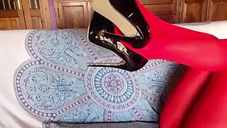 The milf showcases beautiful legs in red pantyhose and black heels. She poses elegantly in the outfit.