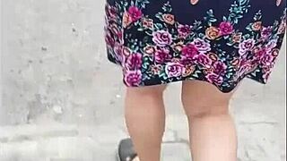 Following a mature woman in a skirt and thong on the street