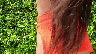 Orange bikini flashing in public outdoor setting